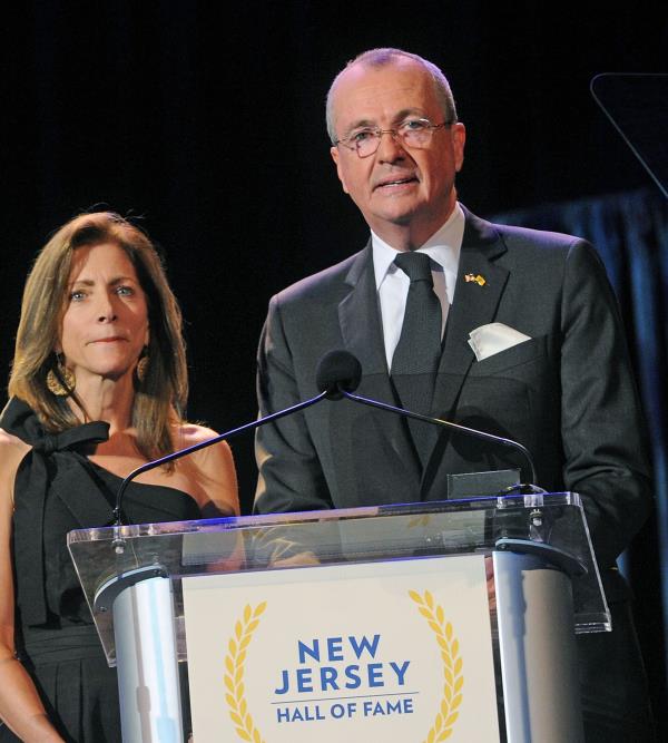 New Jersey First Lady Tammy Murphy (left) stands with her husband NJ Gov. Phil Murphy behind a New Jersey Hall of Fame podium.