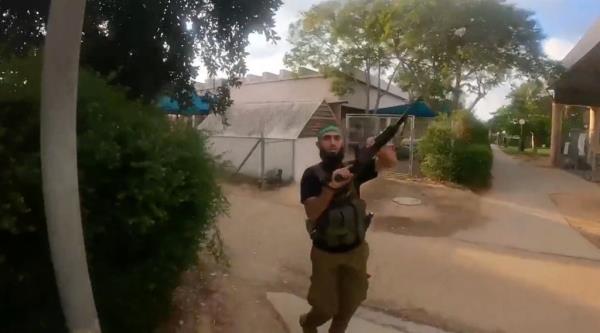 A Hamas militant reloads a long gun in an Israeli community. 