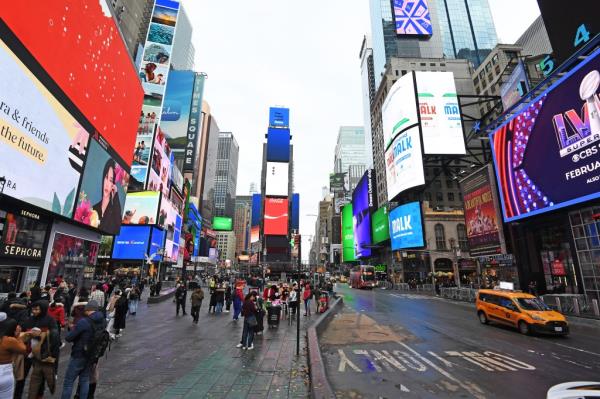 Times Square on New Year's Day morning with tall buildings and people walking, photo by Matthew McDermott