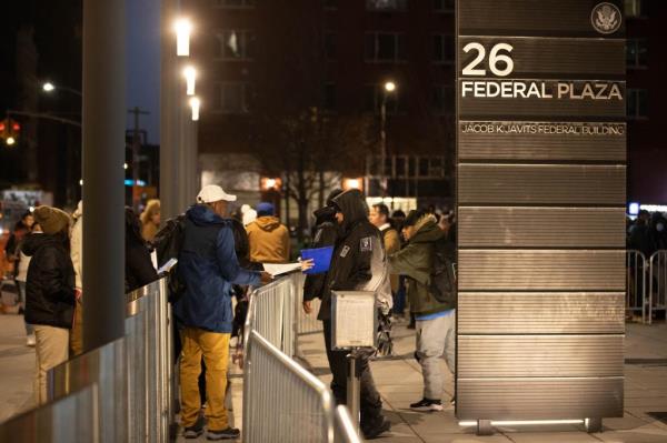 migrants waiting outside building