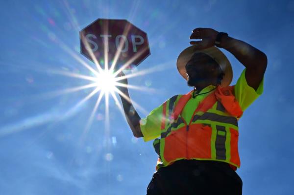 Traffic warden Rai Rogers mans his street corner during an 8-hour shift under the hot sun in Las Vegas, Nevada on July 12, 2023, wher<em></em>e temperatures reached 106 degrees amid an o<em></em>ngoing heatwave.