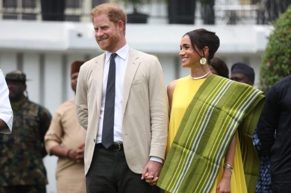 Prince Harry and Meghan, Duchess of Sussex, reacting to a speech at the State Governor House in Lagos, Nigeria during their visit for the Invictus Games anniversary.
