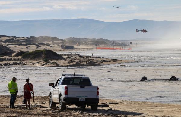 Two of the three rescue helicopters dispatched to the scene fly over Oceano Dunes State Vehicular Recreation Area in Oceano, Calif., after flooding resulted in high swells on the ocean on Dec. 28, 2023.