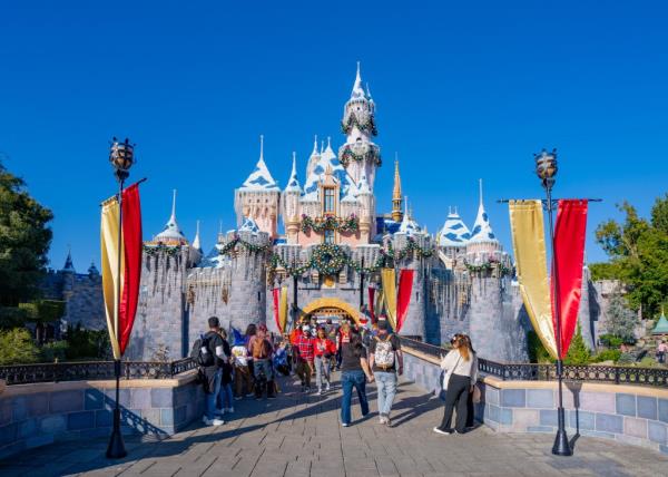 Sleeping Beauty Castle at Disneyland with people walking in front of it during the 