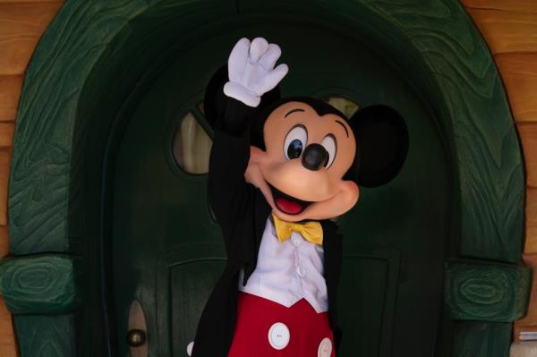 Mickey Mouse dressed person waving at Disneyland.