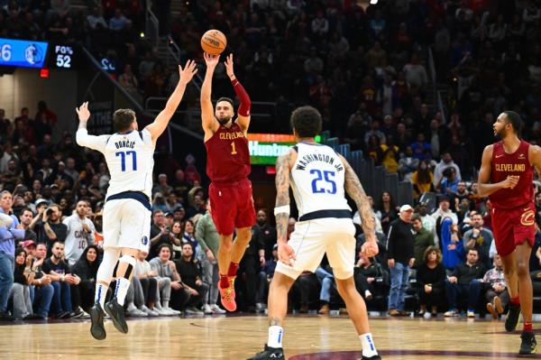 Max Strus #1 of the Cleveland Cavaliers shoots a half-court shot over Luka Do<em></em>ncic #77 of the Dallas Mavericks.