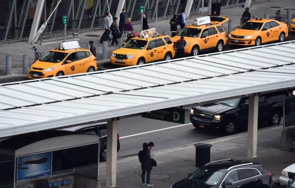 Arriving passengers line up to get taxi outside of Terminal 4 at the JFK airport in New York on Oct. 11, 2014.