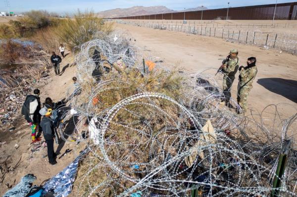 een from an aerial view, Texas Natio<em></em>nal Guard troops watch over immigrants on the other side of razor wire after they crossed into El Paso, Texas on Jan. 30.