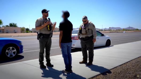 Deputy Frank Sloup talks to a driver he has pulled over, while a colleague watches