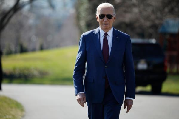 U.S. President Joe Biden walks over to journalists to talk a<em></em>bout new Russian sanctions as he departs the White House on Feb. 20.
