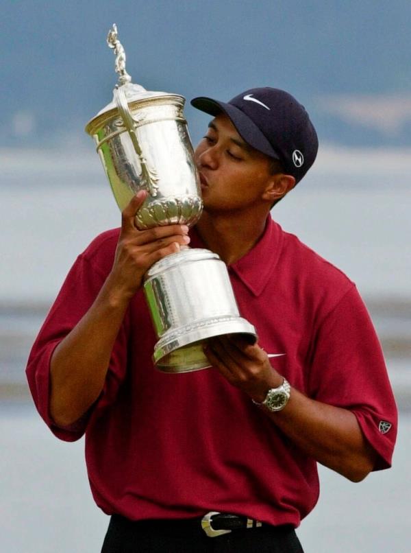 Tiger kissing a winners trophy 