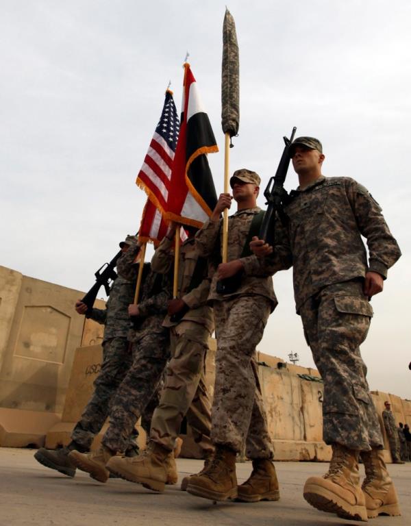 US soldiers carry the Iraqi and US natio<em></em>nal flags during a flag retirement ceremony on Dec. 15, 2011 at Baghdad Diplomatic Support Center, marking the end of the US military engagement in the country. 