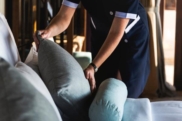 Hotel maid fixing pillows
