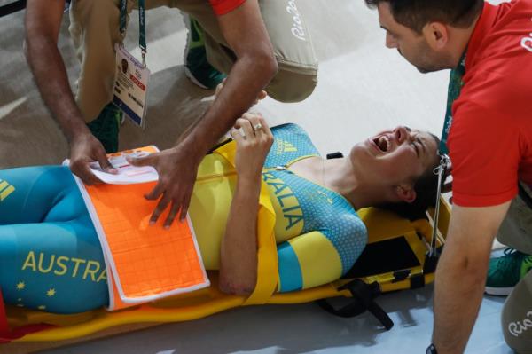 Melissa Hoskins of the Australian women's track cycling team is tended to after crashing during a training session inside the Rio Olympic Velodrome during the 2016 Olympic Games in Rio de Janeiro, Brazil, Monday, Aug. 8, 2016. (AP Photo/Pavel Golovkin)