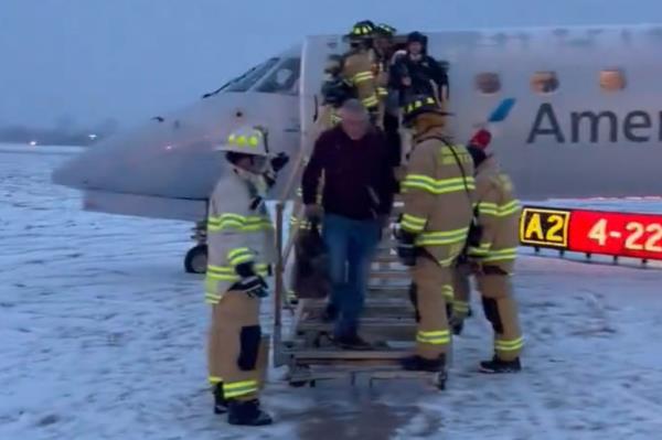 Firefighters escort passengers off the plane.