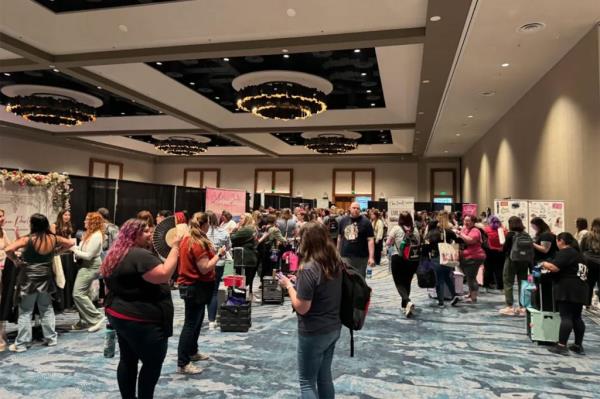 Dozens of attendees stand around at the event.