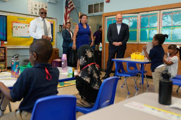People in a classroom with New York City Mayor Eric Adams and New York City Department of Education Chancellor David Banks.