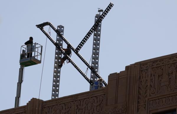 Workers prepare to dismantle the X logo on Monday.
