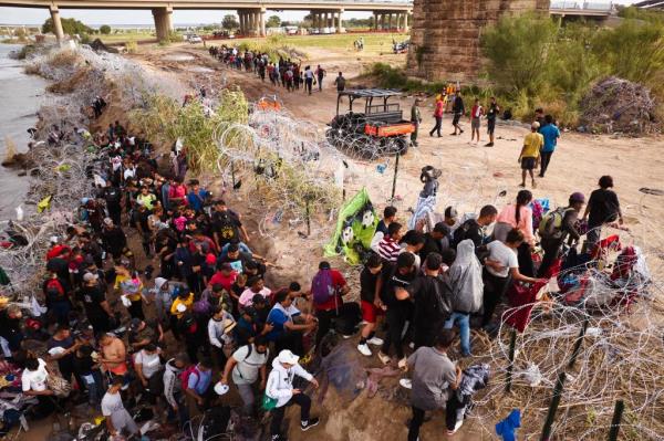 Migrants cross the Rio Grande river from Mexico into the United States on Saturday, September 30, 2023