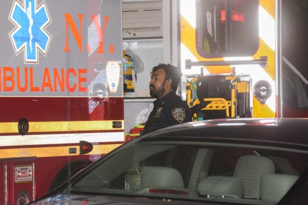 Cop standing near ambulance.
