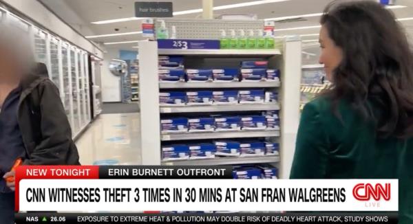 A man with stolen goods walks past CNN reporter Kyung Lah in a story aired Mo<em></em>nday night. 