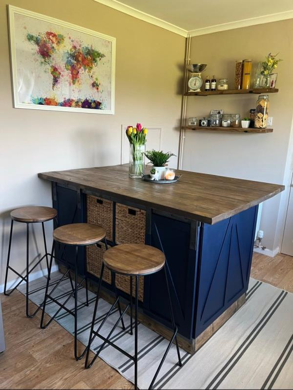 Finished kitchen island with shelves in the background.