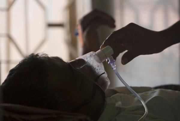 FILE - A relative adjusts the oxygen mask of a tuberculosis patient at a TB hospital on World Tuberculosis Day in Hyderabad, India, March 24, 2018. Top U.N. officials and health industry leaders are trying to tackle an alarming surge in tuberculosis, which is now killing more people worldwide than COVID-19 or AIDS. Among the problems: a high number of cases in co<em></em>nflict zones, including Ukraine and Sudan, wher<em></em>e it’s difficult to track down people with the disease and diagnose new sufferers. (AP Photo/Mahesh Kumar A., File)