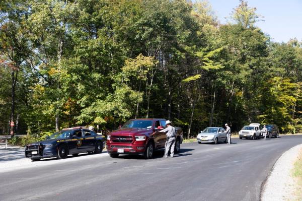 Police search vehicles near Moreau Lake State Park on Monday.