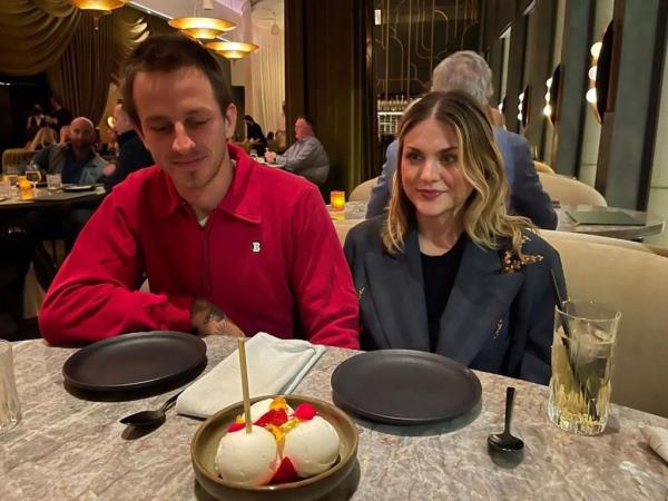 Frances Bean Cobain and Riley Hawk sitting at a table in front of a dessert
