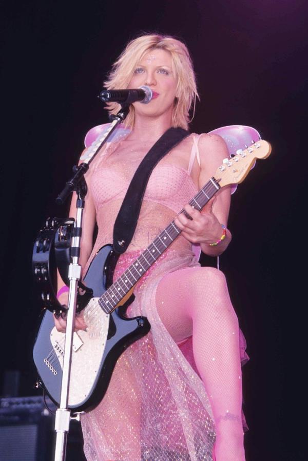  Courtney Love playing the guitar at a micropone stand