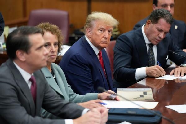 Former President Do<em></em>nald Trump sitting at the defense table with his legal team during a court trial in Manhattan, New York, April 4, 2023.
