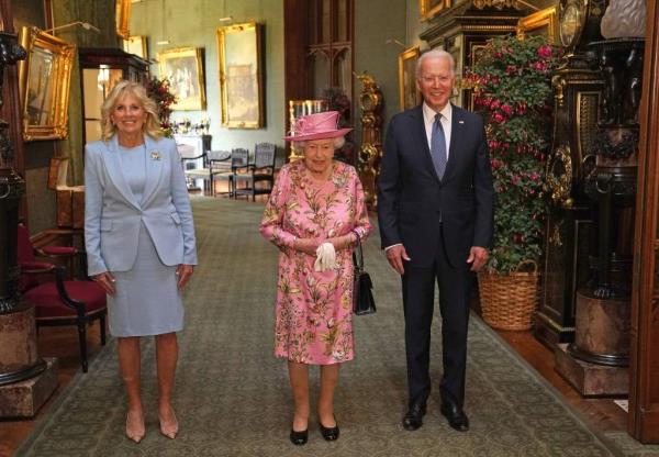 US President Joe Biden (R) and US First Lady Jill Biden (L) pose for a photograph with Britain's Queen Elizabeth II  (C) in the Grand Corridor at Windsor Castle in Windsor, west of London, on June 13, 2021, before taking tea. - US president Biden will visit the queen at Windsor Castle late Sunday, wher<em></em>e he and First Lady Jill Biden will take tea with the queen. (Photo by Steve Parsons / POOL / AFP) (Photo by STEVE PARSONS/POOL/AFP via Getty Images)