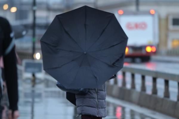 Commuters cross Lo<em></em>ndon Bridge during wet and windy weather in Central Lo<em></em>ndon as yellow weather warnings issued