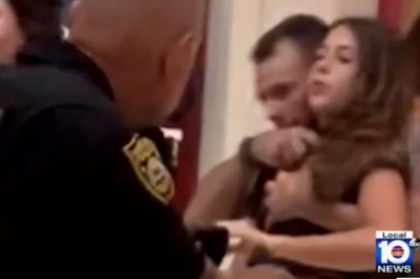 Young is seen holding the young girl at knifepoint as police move in.