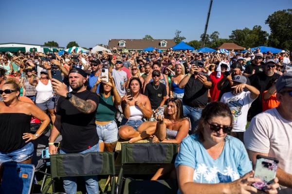 Thousands of fans crowd the golf course around Eagle Creek Golf Club and Grill in Moyock, N.C., on Saturday, Aug. 19, 2023, to watch overnight star Oliver Anthony perform. 