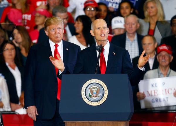 President Do<em></em>nald Trump stands behind Florida Gov. Rick Scott as he speaks at a rally in Pensacola, Fla. Scott defeated U.S. Senator Bill Nelson.