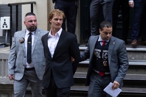 Daniel Penny being led in handcuffs.