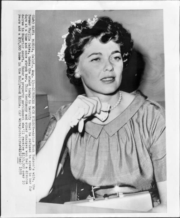 Phyllis Gates testifying in court during her divorce from actor Rock Hudson, holding a necklace