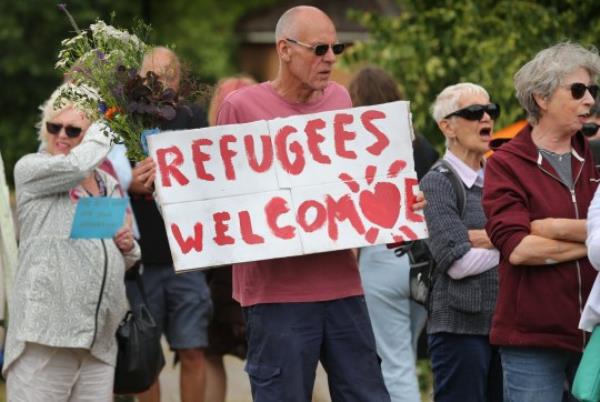 NORWICH, ENGLAND - JULY 1: Stand Up To Racism protesters protest outside The Brook Hotel one carries a sign saying 'Refugees Welcome' on July 1, 2023 in Norwich, England. The East Anglian Patriots hold a demo<em></em>nstration outside The Brook Hotel. They say no more migrants put up in hotels in Norwich. (Photo by Martin Pope/Getty Images)