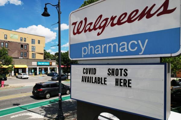 A sign outside a Walgreens Pharmacy advertises that COVID shots are available.