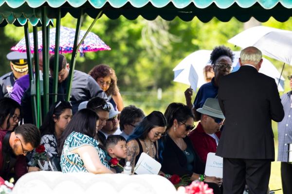 Family members praying at the graveside funeral service.