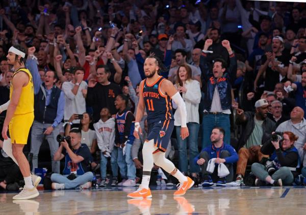 Knicks guard Jalen Brunson #11 on the court as fans react after scoring during the fourth quarter.