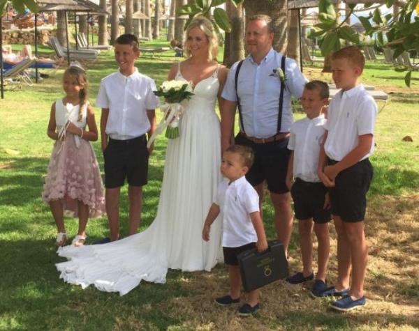 Cheryl and her husband on their wedding day with their children around them
