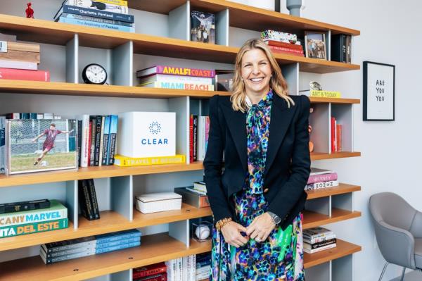 CLEAR CEO Caryn Seidman-Becker standing in front of a bookshelf at CLEAR headquarters in Chelsea, Manhattan.