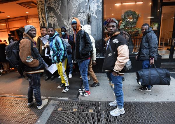 Migrants outside the Roosevelt Hotel shelter