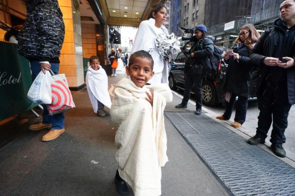 Migrants depart Roosevelt Hotel, walk around the corner wher<em></em>e they boarded a city bus that left shortly thereafter.