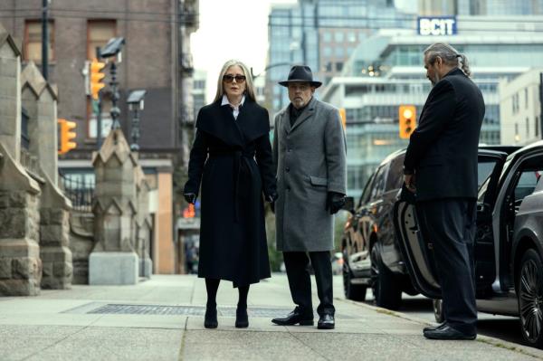 Mary McDo<em></em>nnell as Madeline Usher, and Mark Hamill as the shady family lawyer, standing on a city sidewalk. 