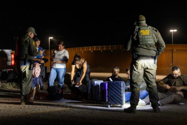 Border Patrol agents searching a group of migrants near the border in Yuma, Arizona on May 16, 2024.
