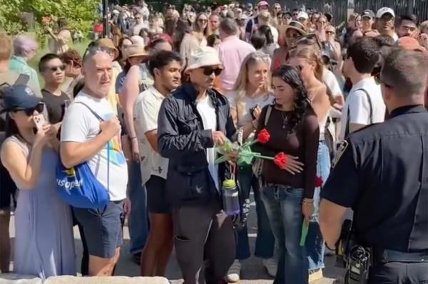 Police shutting down an overcrowded art event featuring thousands of plush flowers in a large white tent on Roosevelt Island, New York City.