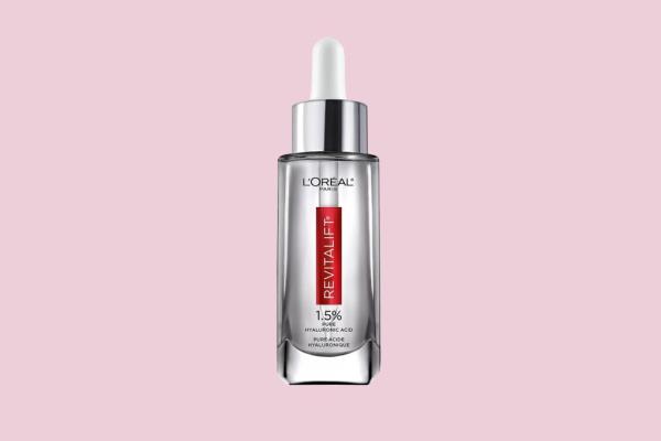 Eva Lo<em></em>ngoria holding a clear bottle with a dropper for Revitalift product